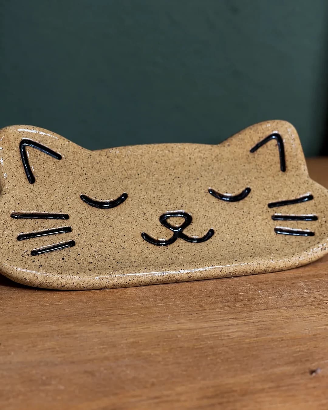 Porta-joias gato, em cerâmica feita à mão por Pauliria Queiroz, sobre a prateleira do ateliê